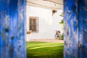 una bicicleta estacionada frente a un edificio blanco en Casa Rural La Alameda, en Madridejos
