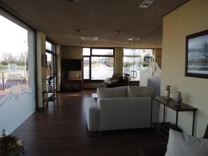 Una sala de estar con un sofá y un televisor. en Hotel Rural Corazón de las Arribes, en Aldeadávila de la Ribera