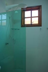bagno con doccia e finestra di Pousada da Ju a Guarujá