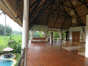 um quarto amplo com piso em madeira e uma piscina em Frangipani Villas em Ubud