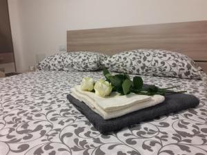 a bed with two towels and flowers on it at casa Fantulìn Mare in Laigueglia