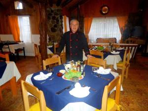 a man standing at a table in a restaurant at Hosteria Rayen in La Junta