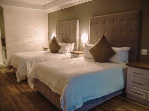 una habitación de hotel con 2 camas en una habitación en HERMS Restaurant & Boutique Hotel, en Port Elizabeth