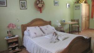 un dormitorio con una cama con una muñeca sentada en ella en Casa das Oliveiras en Flassans-sur-Issole