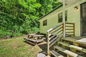 - une table de pique-nique et des escaliers menant à une maison verte dans l'établissement Nantahala Cabins, à Bryson City