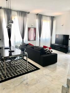 a living room with a black couch and a glass table at Maison Beaux-Arts in Sanremo