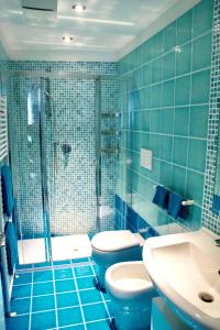 a blue tiled bathroom with a toilet and a shower at Maison Beaux-Arts in Sanremo