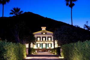 una gran casa blanca con luces encendidas por la noche en Hotel Rural Sant Patrici, en Ferreries
