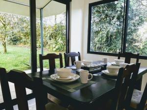 een eettafel met kopjes en schotels erop bij Casa Mirango Boquete in Boquete