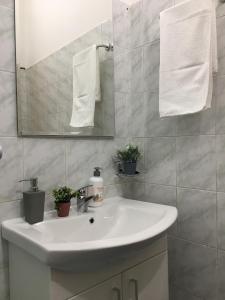 y baño con lavabo blanco y espejo. en Apartments Valentina - free parking, en Mostar