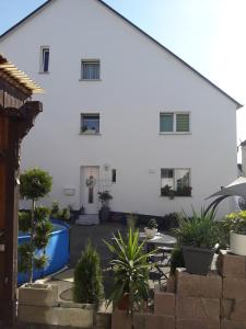 a white building with a courtyard with potted plants at Gemütliche Zimmer in Kaisersesch