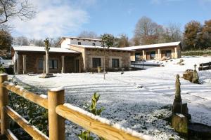 una casa cubierta de nieve frente a una valla en Casa Barbadelo, en Sarria
