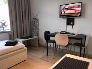 Dieses kleine Zimmer verfügt über einen Schreibtisch und einen TV an der Wand. in der Unterkunft HertenFlats - Rooms & Apartments - Kreis Recklinghausen in Herten