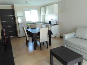 pequeña sala de estar con mesa y cocina en Apartamentos Valeria en Valeria del Mar