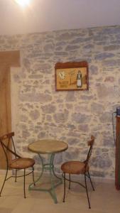 a table and two chairs in front of a stone wall at La maison de l'écluse in Trèbes