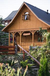 a log cabin with a porch and a window at Pienińskie Herbarium zdrowie i dobre samopoczucie in Grywałd