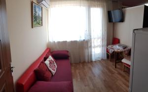 a living room with a red couch and a table at TravelStop #GoldenSea in Varna City