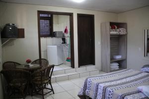 Apartamento Bella Vista Gramado في غرامادو: غرفة مع طاولة وكراسي ومطبخ