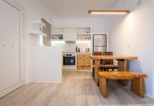 uma cozinha com uma mesa de madeira e um banco de madeira em Akis Luxury House em Adamas
