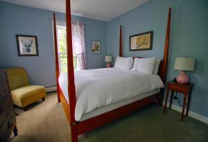 a bedroom with a large bed and a chair at The Wilmington Inn in Wilmington