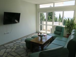 a living room with a couch and a tv at Green Hill Hotel in Stara Zagora