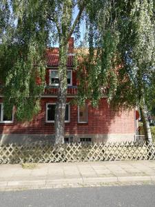 a red brick building with two trees in front of it at Ferienwohnung"Zur Birke" in Winsen