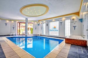 a large swimming pool in a room with a large tub at Apartament Baltic Star Rewal in Rewal