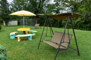 a swing and a table and umbrella in a yard at Americas Best Value Inn & Suites Williamstown in Williamstown