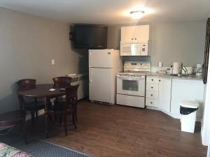 a kitchen with a table and a white refrigerator at The Gables Inn in Sarnia