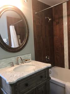 a bathroom with a sink and a tub and a mirror at The Gables Inn in Sarnia +50 photos