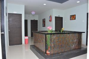 a lobby with two doors and a vase with flowers at Hotel neptune in Amreli