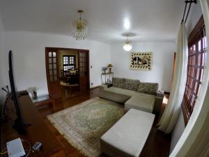 uma sala de estar com um sofá e uma mesa em Confortável casa de madeira em Poços de Caldas