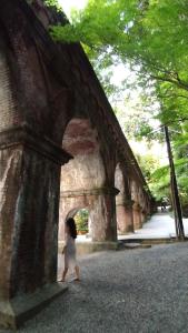 a little girl walking under a stone bridge at Kinkaku in Kyoto