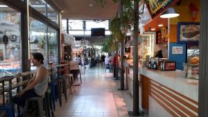 a woman sitting at a bar in a grocery store at Apartamento Pleno Centro Victoria PARKING GRATIS in Córdoba