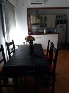 stół jadalny z wazonem kwiatów w obiekcie Apartamento Lautaro w BuenosAires