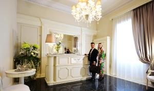 Un uomo e una donna in piedi in una stanza di The Moon Boutique Hotel & Spa a Firenze