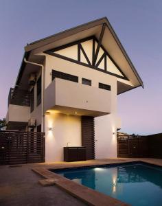 a house with a swimming pool in front of it at GreyStone Apartments in Nadi