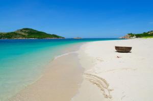 een mand op een strand naast de oceaan bij An Phat Hotel in Con Dao