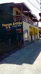 a building with a sign on the side of it at Pousada Aritibe in Ilha de Boipeba