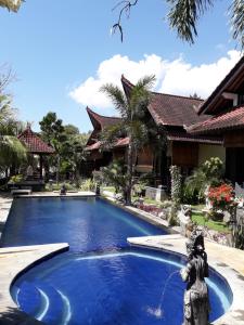 a swimming pool in front of a house at Tradisi Villas in Amed