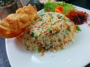 een witte plaat met rijst en groenten en een broodje bij Panora Garden in Mirissa