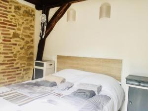 una camera da letto con un letto bianco e asciugamani di 4 Rue Jean Jaurès a Sarlat-la-Canéda