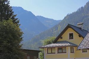 a yellow house with a view of a mountain at Ferienwohnungen Hager in Gosau