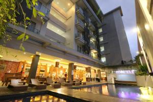 a hotel with a pool in front of a building at Crystal Lotus Hotel Yogyakarta in Yogyakarta