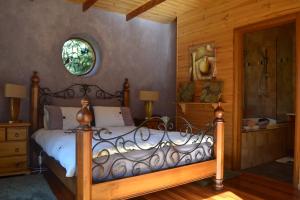 una camera da letto con un letto e una doccia in vetro di Whispering Spirit Holiday Cottages & Mini Ponies a Franklin