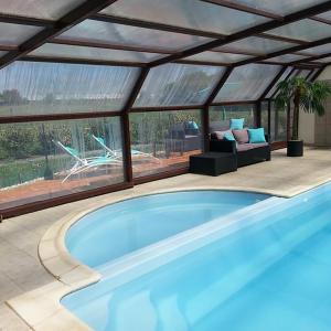 - une piscine dans une maison avec une véranda dans l'établissement Les Gîtes au Soleil Levant, à Talmont-Saint-Hilaire