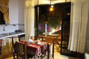 um quarto com uma mesa e uma cozinha com uma janela em Casa Hospedaje"Los Capulies" em Carhuaz