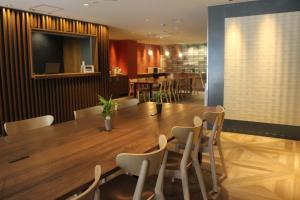 un comedor con una gran mesa de madera y sillas en Hotel Zipang, en Osaka