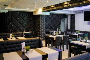 a dining room with tables and chairs and booths at Olympic Apartments& Spa in Belgrade +66 photos