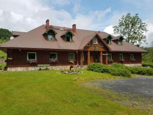 a large wooden house with a gambrel roof at Dom Pod Siódemką in Stronie Śląskie